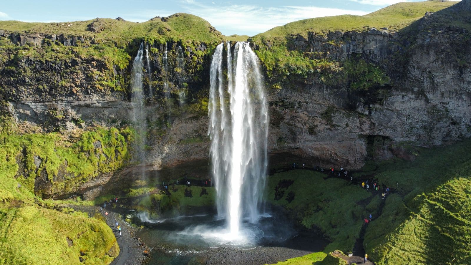 Aerial view of Seljalandsfoss waterfall falling from a green cliff in southern Iceland