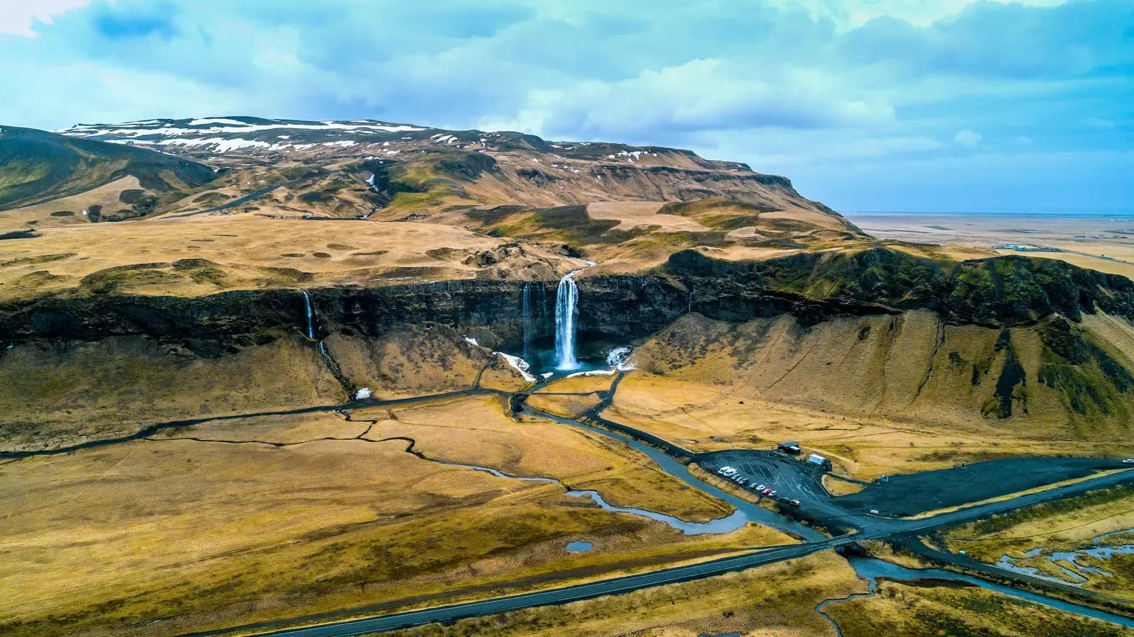 Vue aérienne de la cascade de Seljalandsfoss et des plaines verdoyantes en contrebas