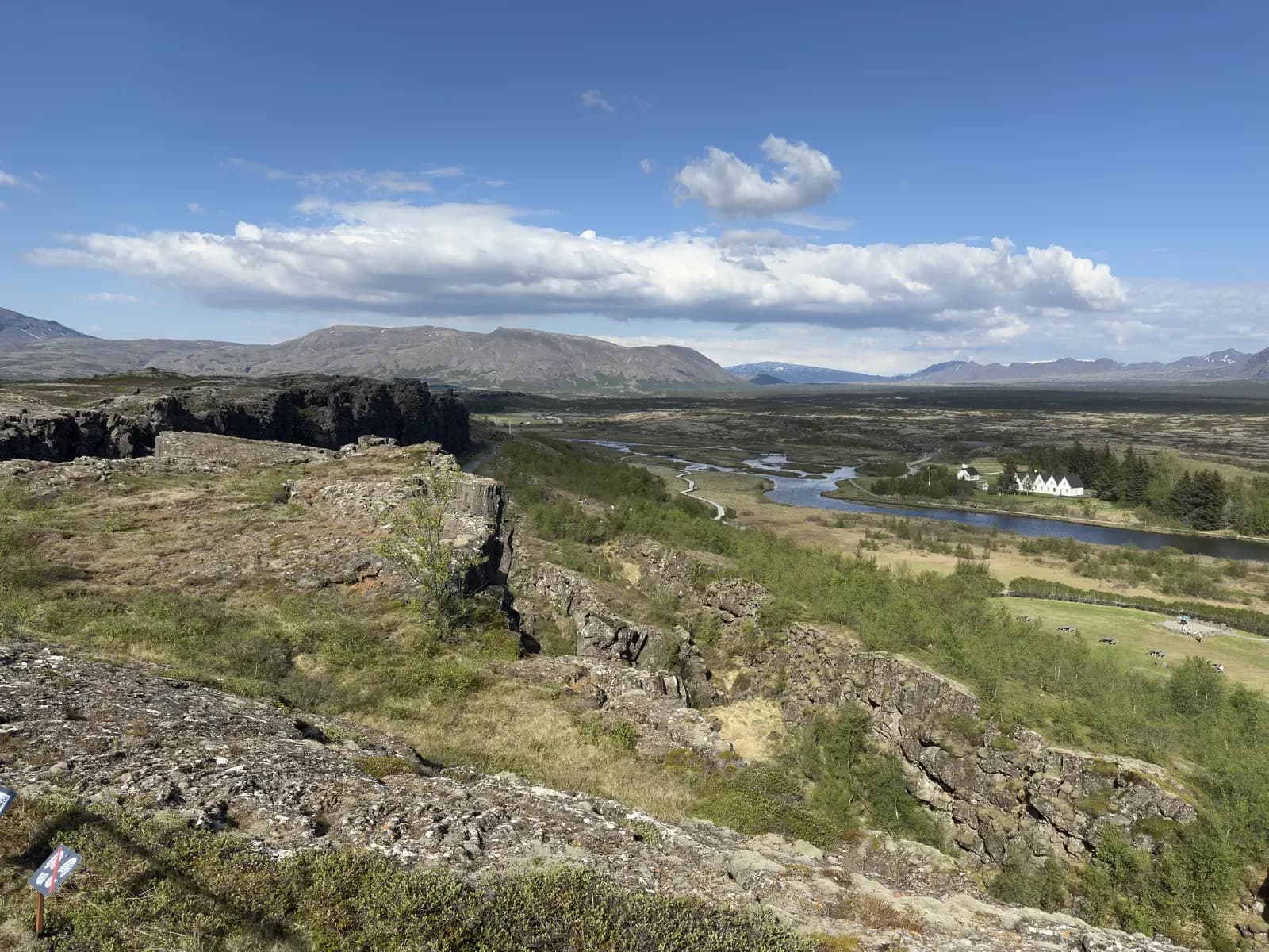 View over the green rift valley of Þingvellir National Park with a lake and mountains