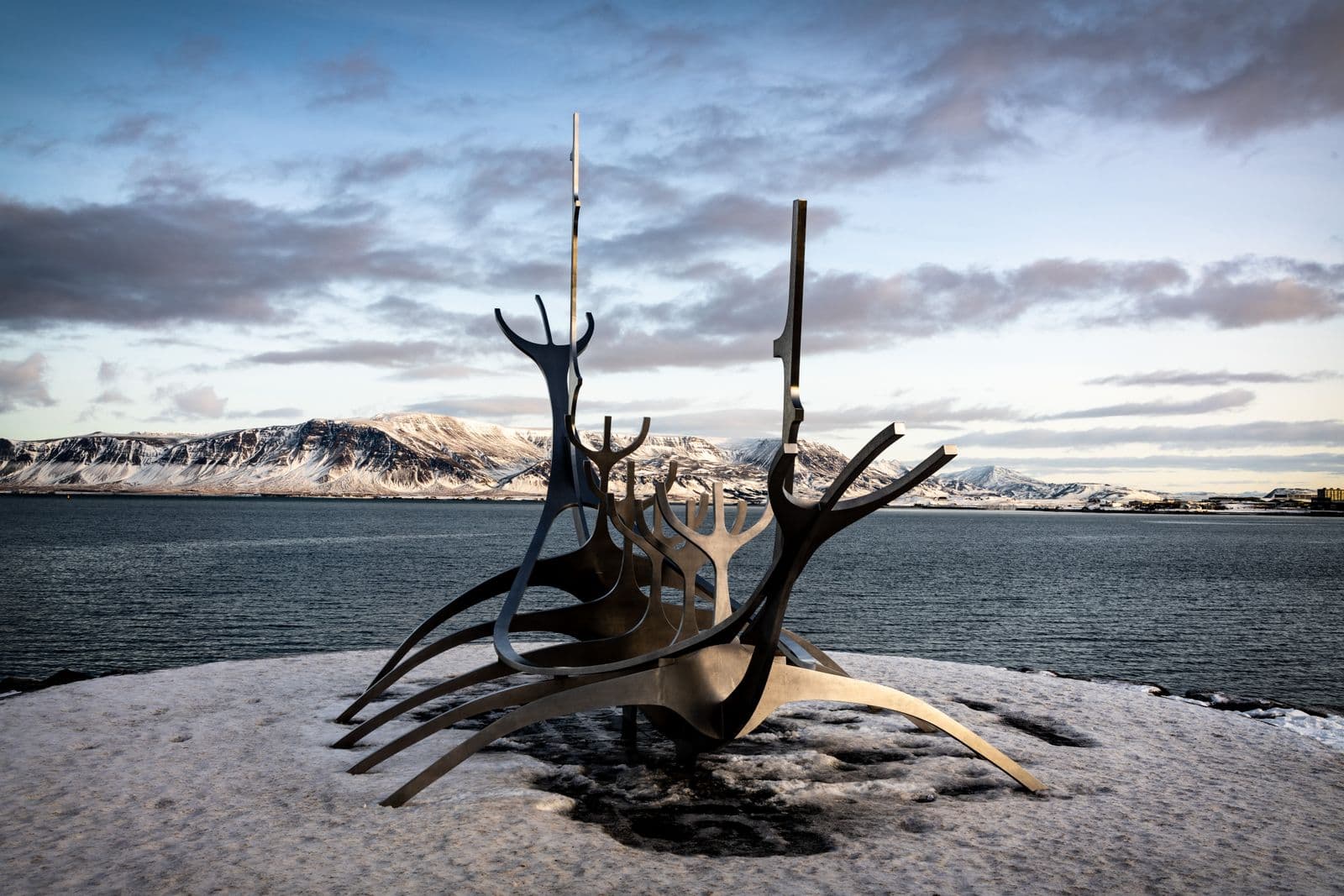 Sun Voyager steel sculpture on the Reykjavík seafront with mountains behind