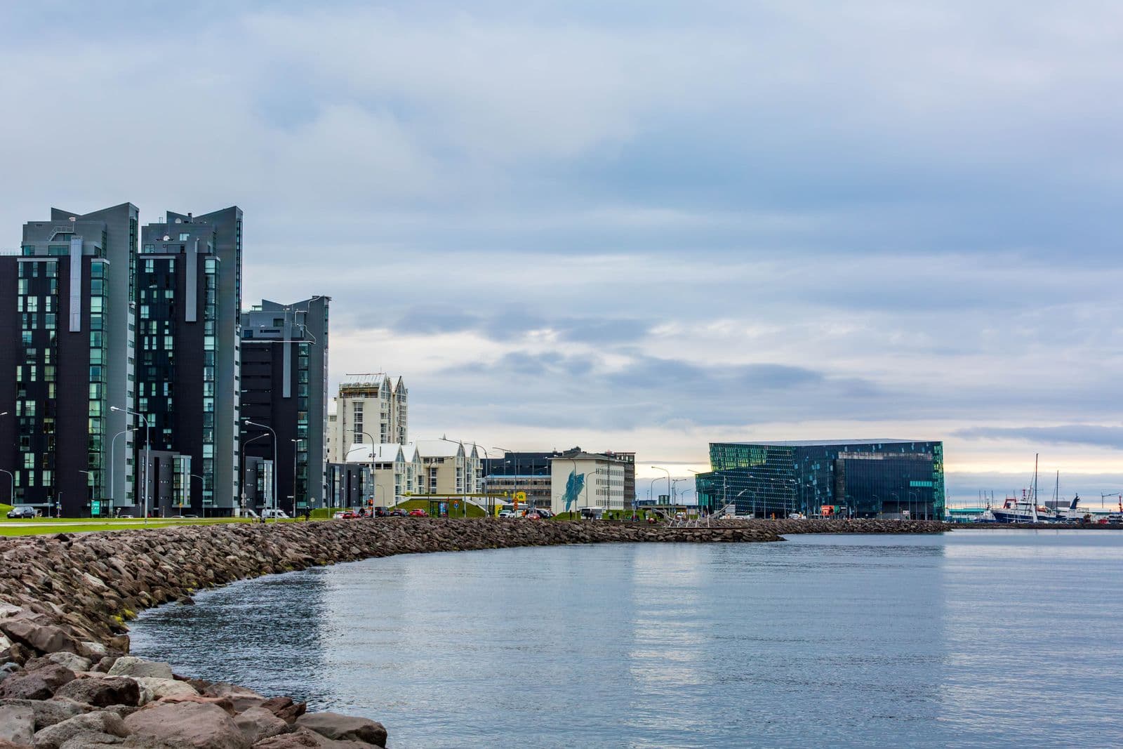 Reykjavík waterfront with modern glass buildings, the harbour and cloudy sky